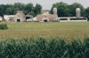 An Iowa farm with corn fields in the foreground.